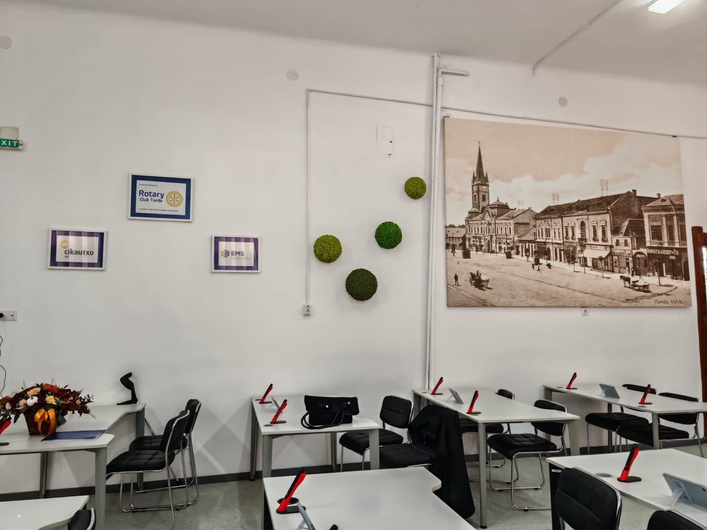 SmartLab-ul de la Colegiul Național „Mihai Viteazul” Turda: mese albe cu tablete, plăcuța „SmartLAB amenajat de Rotary Club Turda” pe perete și o fotografie a Turzii din 1918