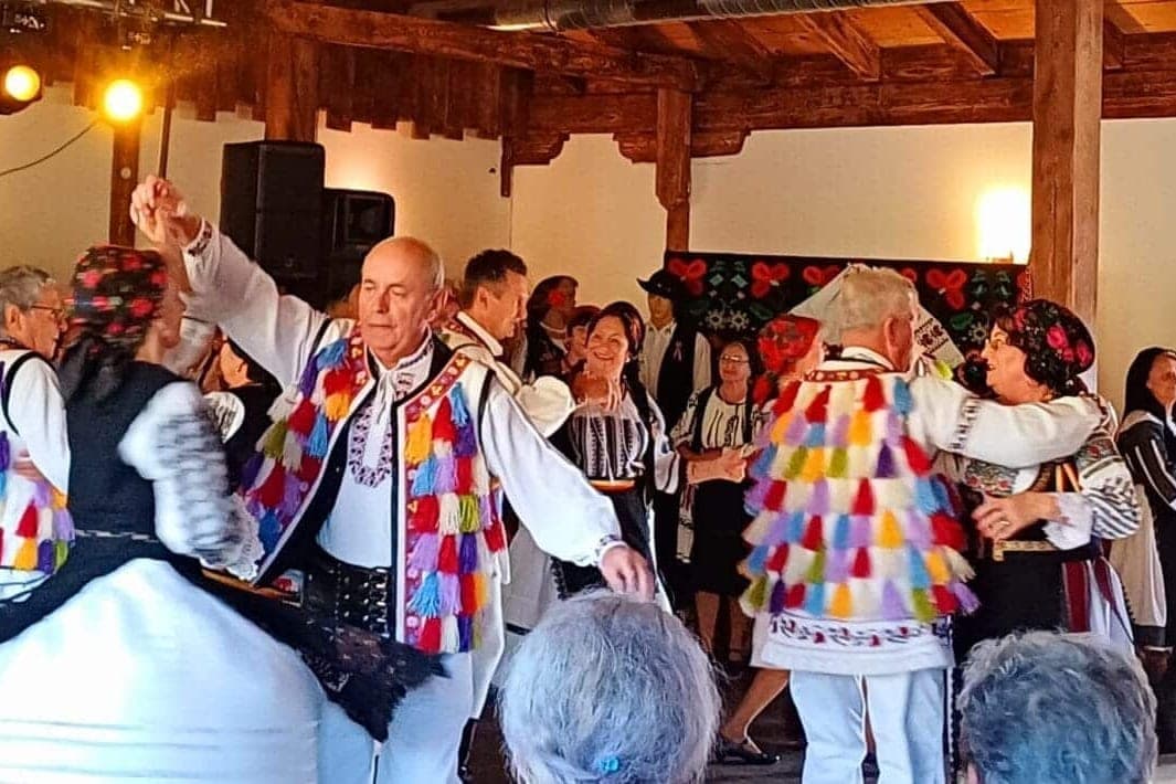 Vârstnici în costume populare dansând în perechi la Festivalul Seniorilor, la Restaurant Talora din Turda